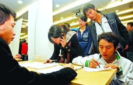 求职者在富士康的招聘台前填写登记表 记者 欧阳祖兵 摄