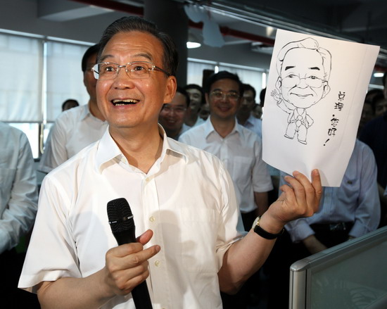 这是7月2日，温家宝在长沙拓维信息系统公司考察时接受员工赠送的漫画像。 新华社记者姚大伟摄