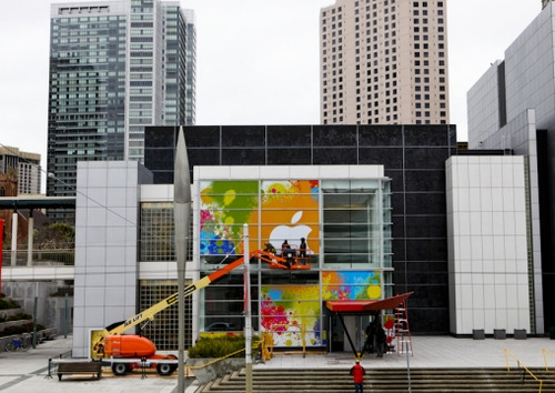 工作人员正在张贴场馆外的苹果logo