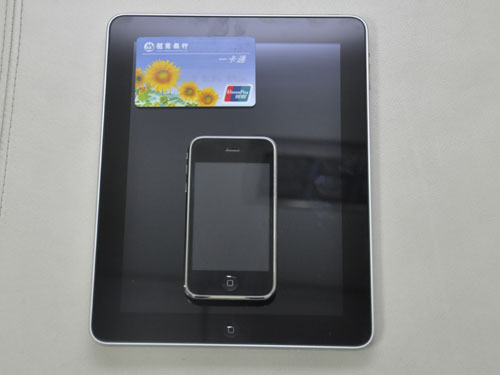 银行卡与iPad和ihone的合影，银行卡只占了屏幕的一个小角落。