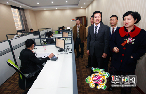 重庆市副市长童小平（右一）在向工作人员了解重庆市中小企业综合服务平台相关功能