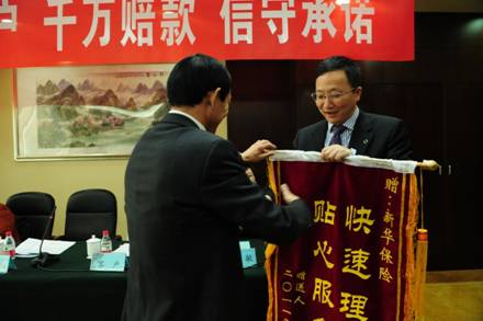 山西千万理赔:新华保险(601336)运营总监陈正阳(右)从杨女士家属手中接过锦旗