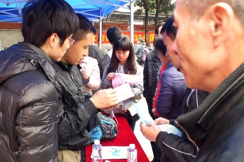 图2：现场工作人员认真解答咨询人员疑问。